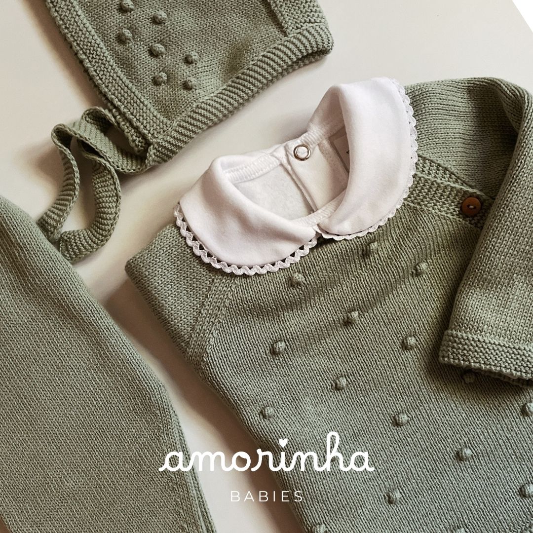Conjunto de roupa de bebé em malha verde com colarinho branco e detalhe de pontos