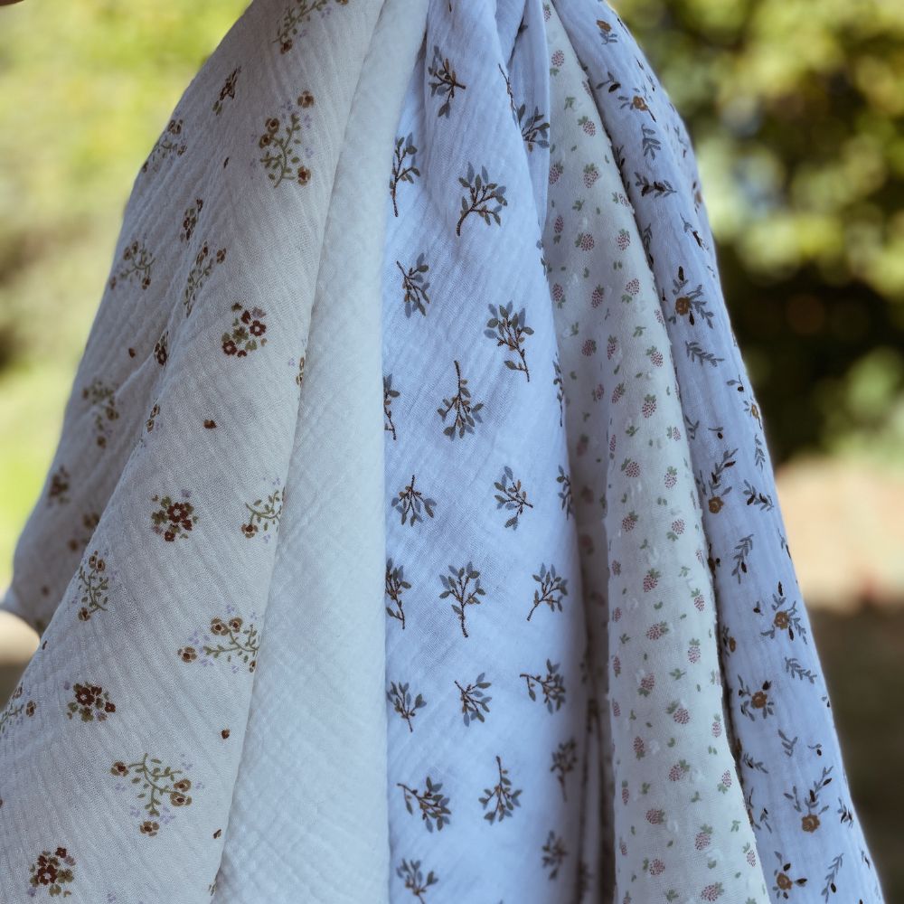 Tecidos florais em algodão com padrões suaves, suspensos ao ar livre