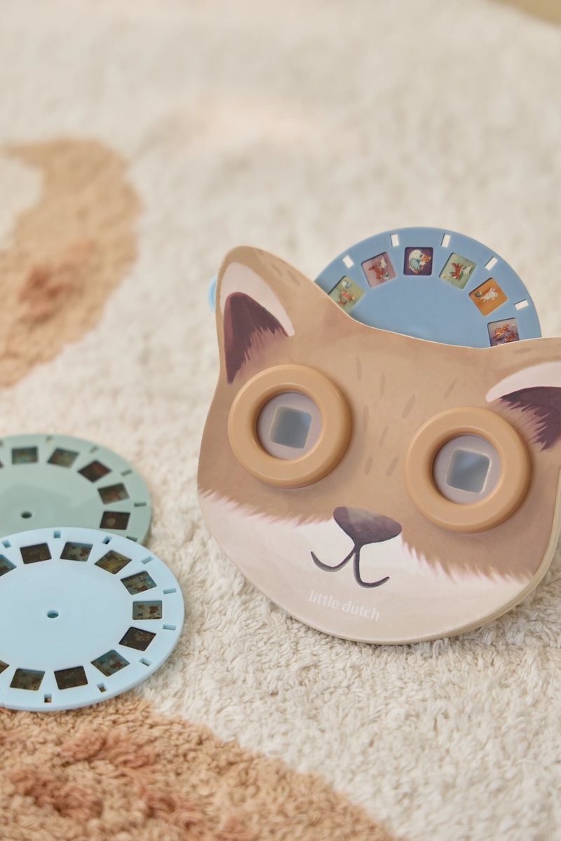 Projetor slides em forma de cabeça de gato com discos azuis sobre tapete