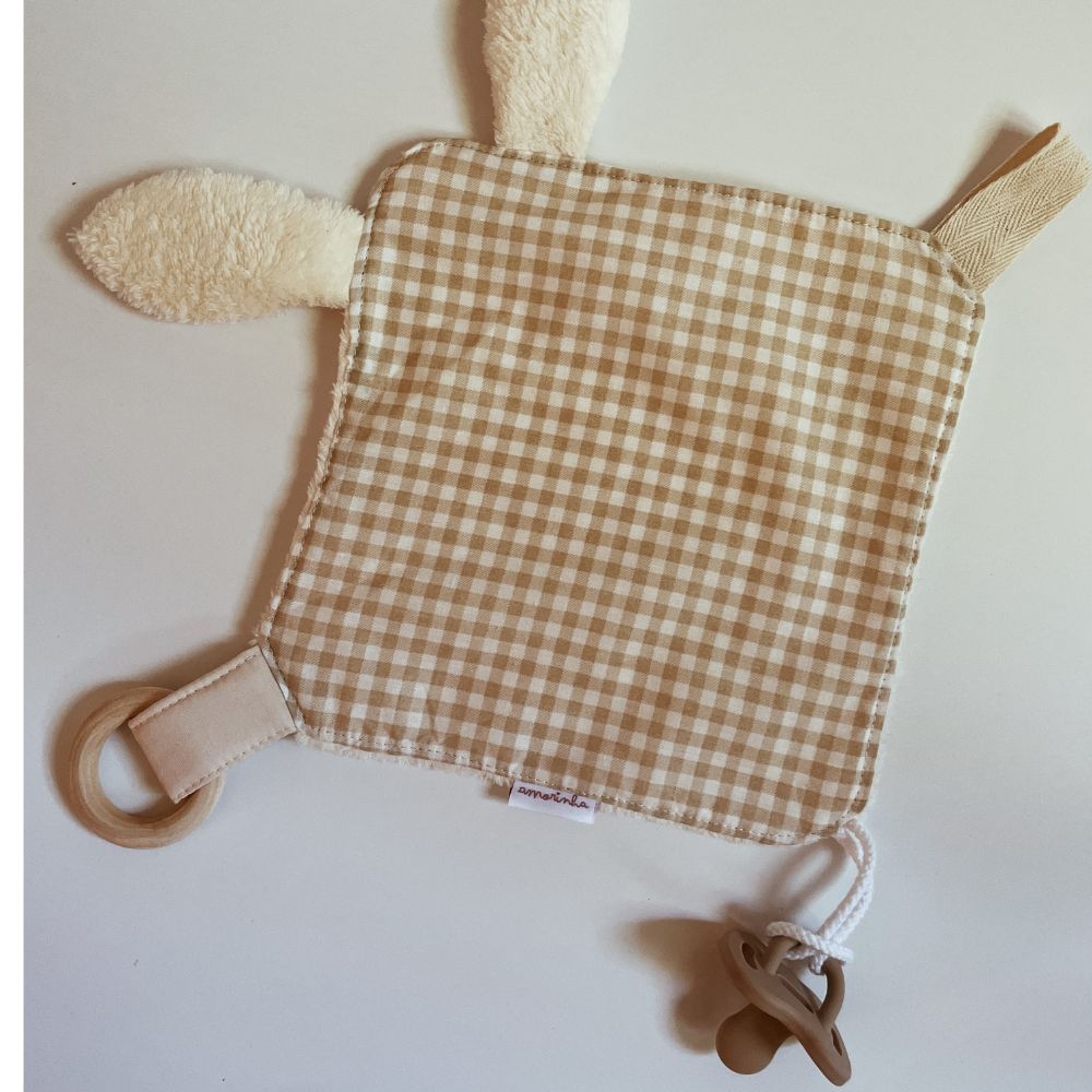 Pano de bebé com padrão às quadrículas bege e branco e acessórios