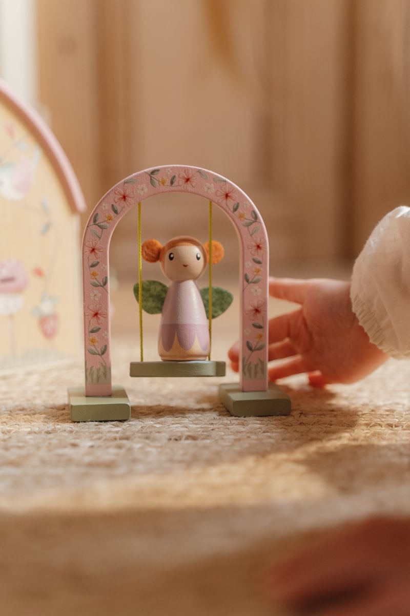 Brinquedo de madeira com balanço e boneca sentada ao centro