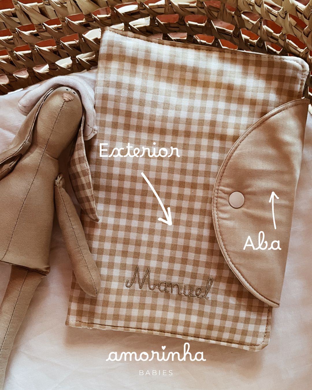 Capa xadrez bege com nome e coelho de tecido ao lado numa cesta