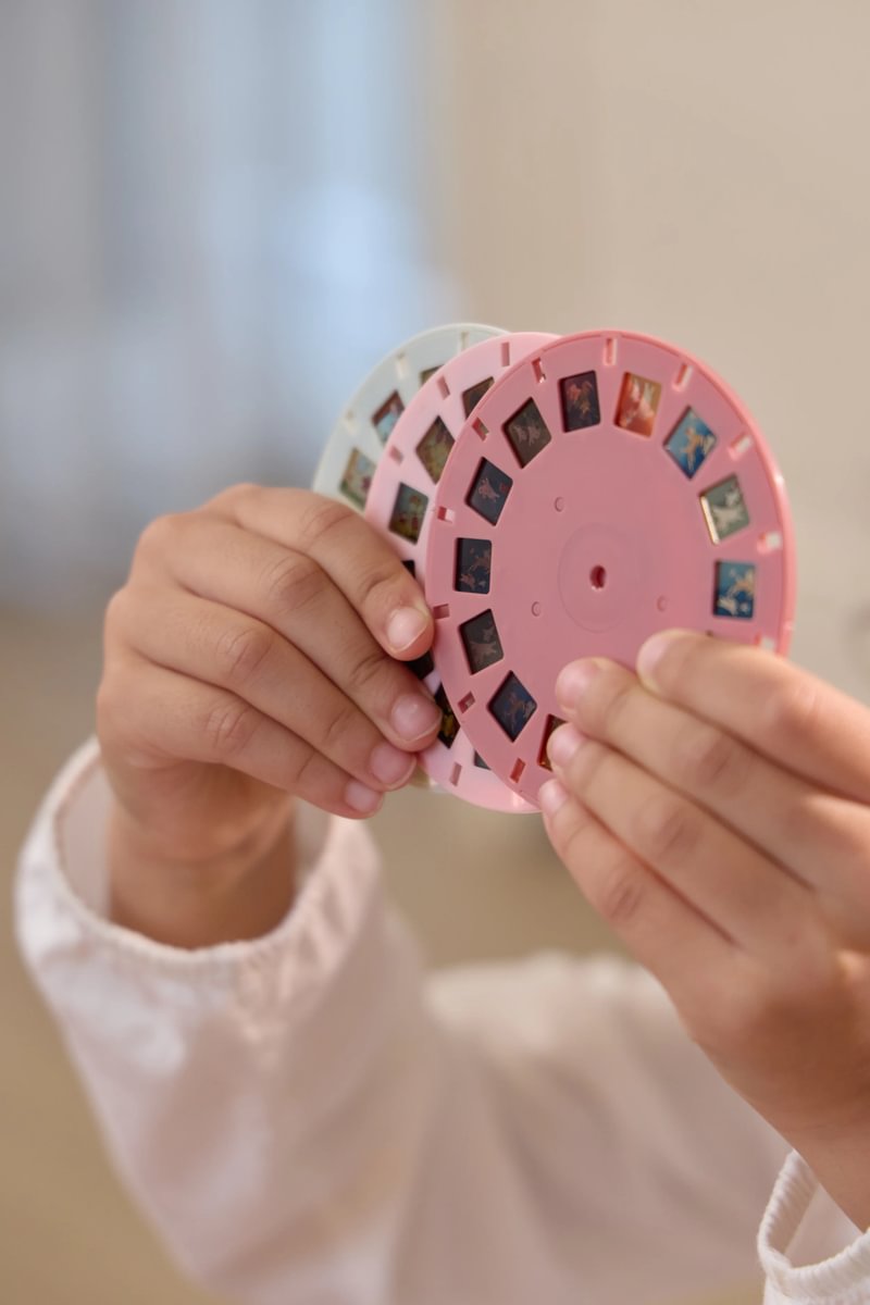 Criança segurando carretéis de plástico coloridos com imagens para visualização