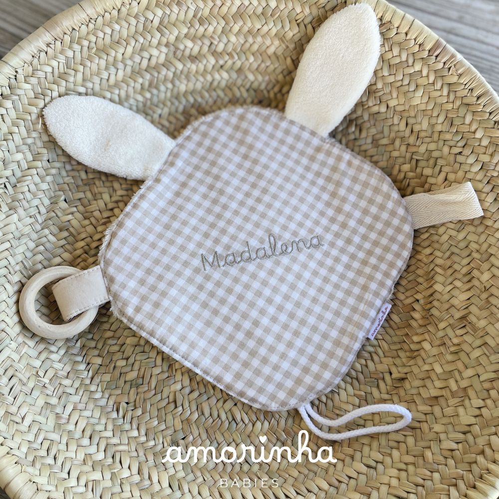 Manta de bebé xadrez bege e branco com bordado Madalena e anel de madeira