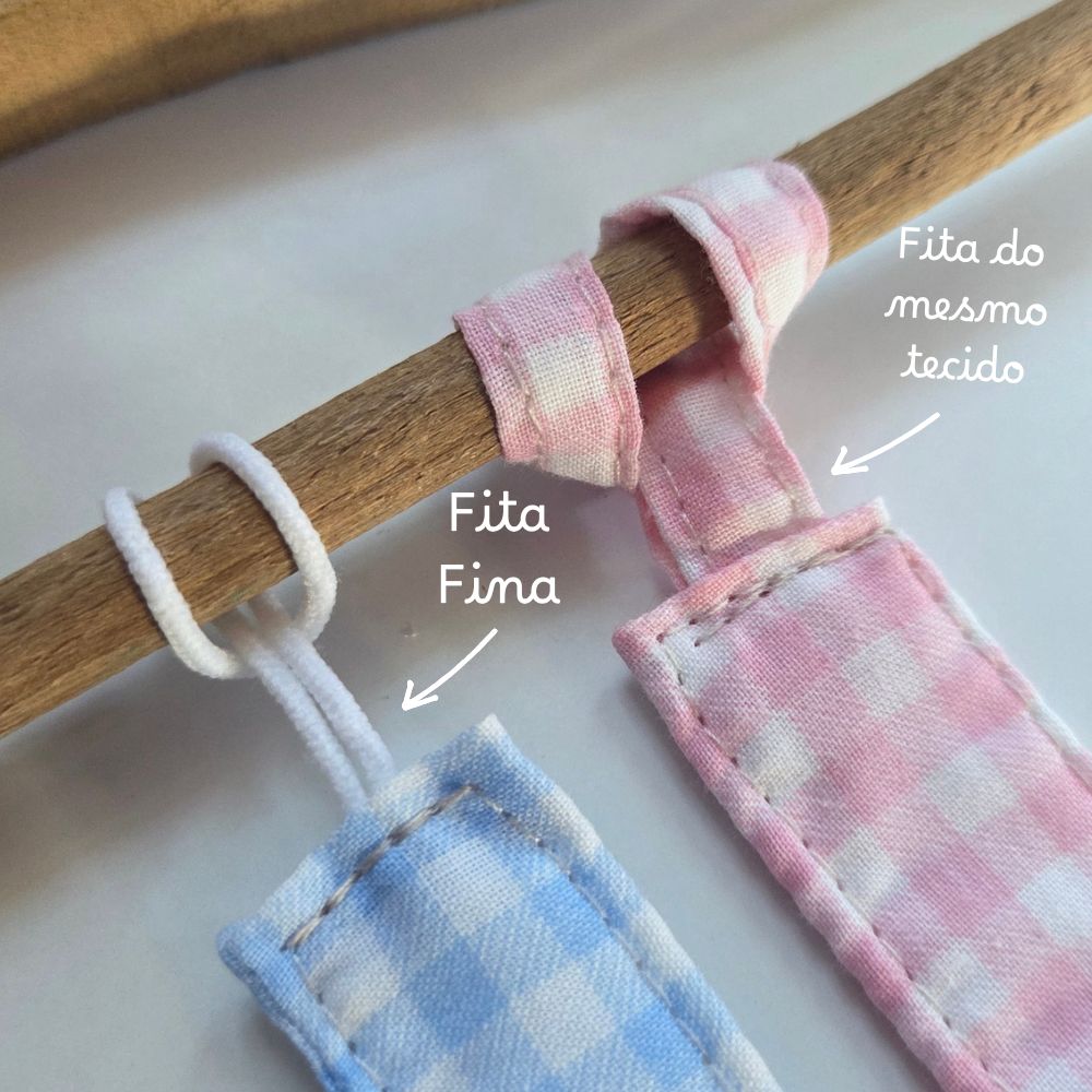 Peças de tecido xadrez azul e rosa com fitas para pendurar num cabo de madeira