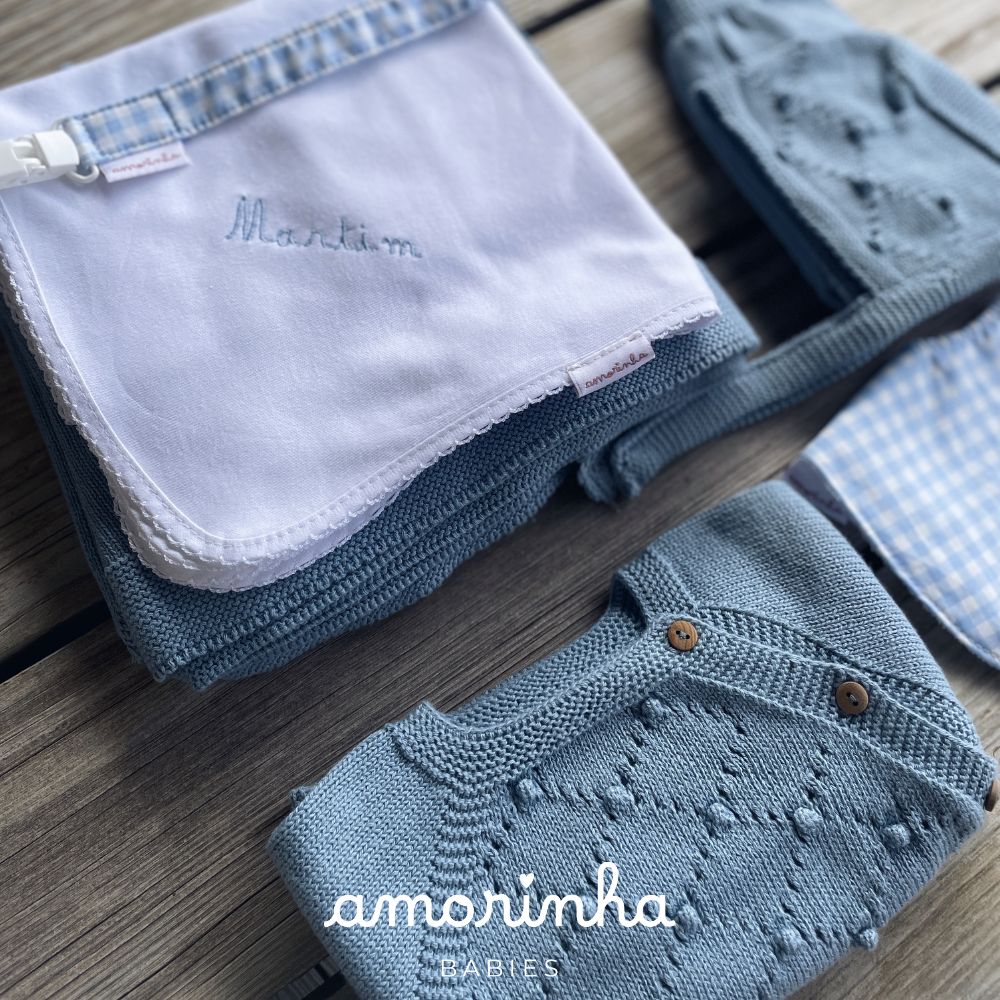 Conjunto de bebé azul em malha com detalhes e pano branco bordado com nome Martim