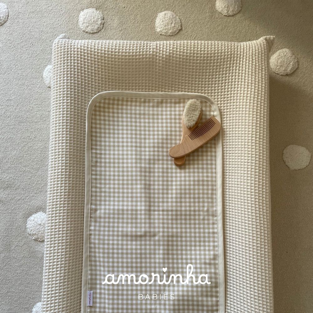 Colchão de bebé com capa bege, manta quadriculada, escova e pente de madeira