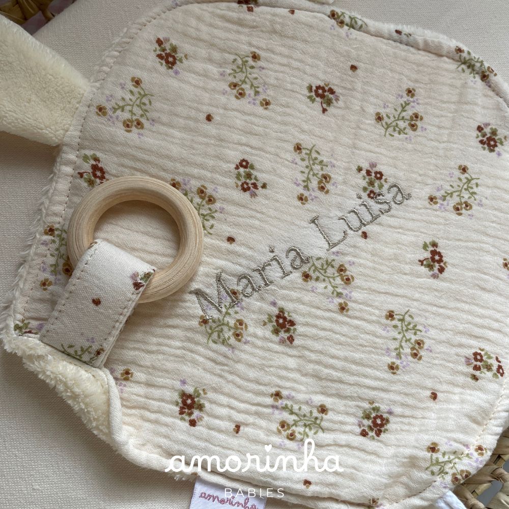 Produto têxtil redondo com padrão floral e argola de madeira