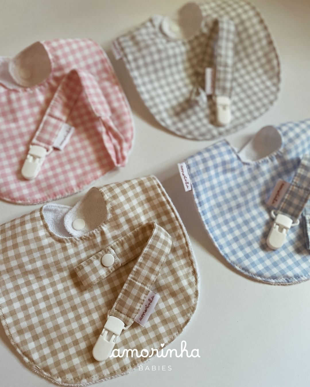 Babete e porta-chupeta de padrão xadrez em várias cores