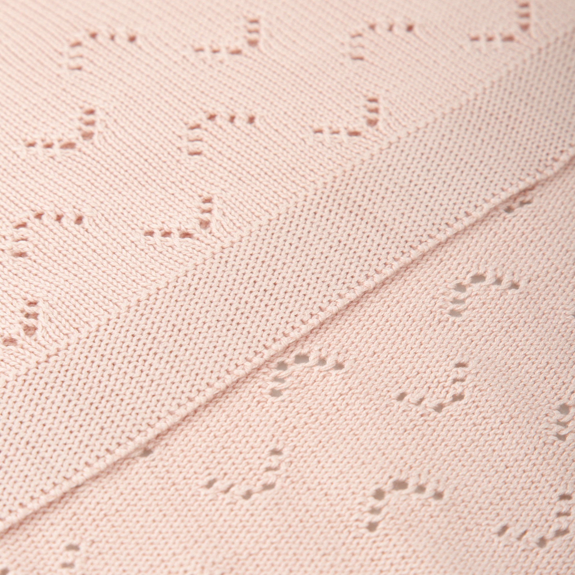 Tecido cor-de-rosa claro com padrão de coração em relevo e textura de malha