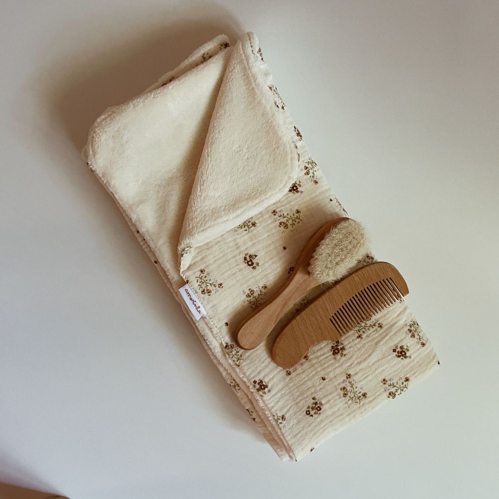 Conjunto de manta, pente e escova para bebé em fundo branco