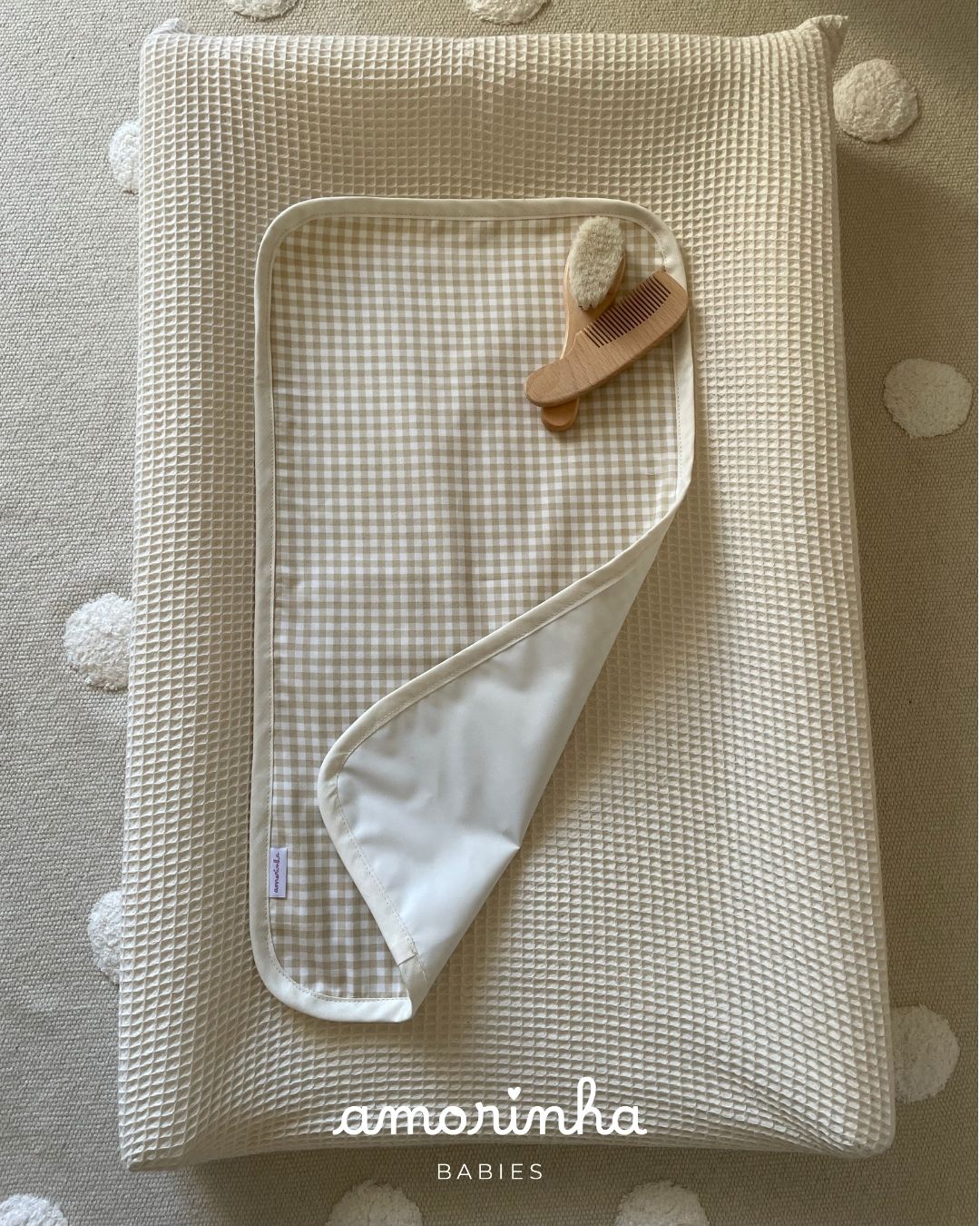 Colchão de muda com toalha xadrez e acessórios para bebé