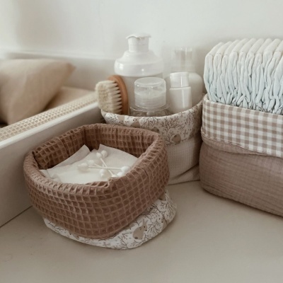 Cestas de tecido em tons beges com itens de cuidados pessoais e cotonetes