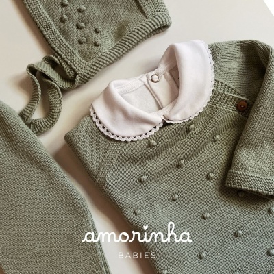 Conjunto de roupa de bebé em malha verde com colarinho branco e detalhe de pontos