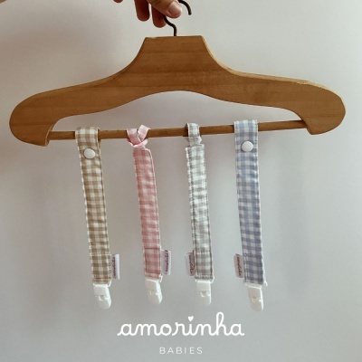 Presilhas para chupeta de tecido xadrez coloridas penduradas em cabide de madeira