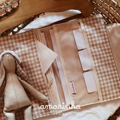 Carteira organizadora bege com padrão xadrez e boneco de pano ao lado