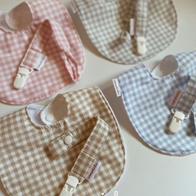 Babete e porta-chupeta de padrão xadrez em várias cores