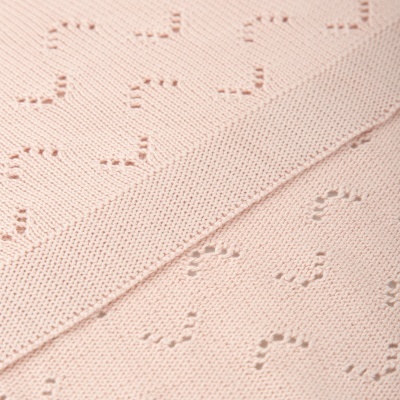 Tecido cor-de-rosa claro com padrão de coração em relevo e textura de malha