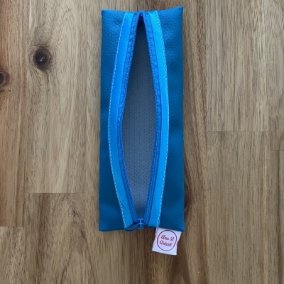 Estojo azul de tecido com fecho de correr azul e etiqueta Ana B Artesã