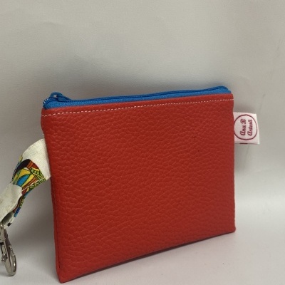 Carteira pequena de couro vermelho com fecho azul e etiqueta Ana B Artesã
