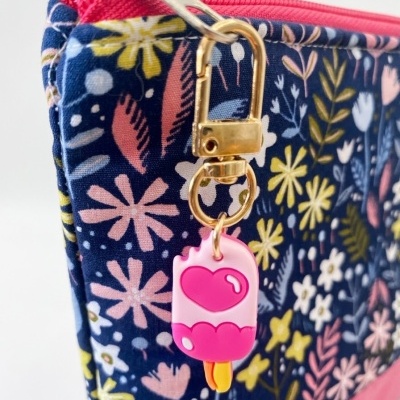Estojo com padrão floral colorido e pendente de gelado rosa