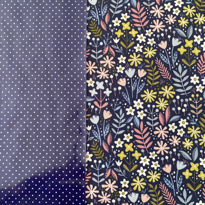 Dois tecidos com padrões em azul escuro, bolinhas brancas e flores coloridas.