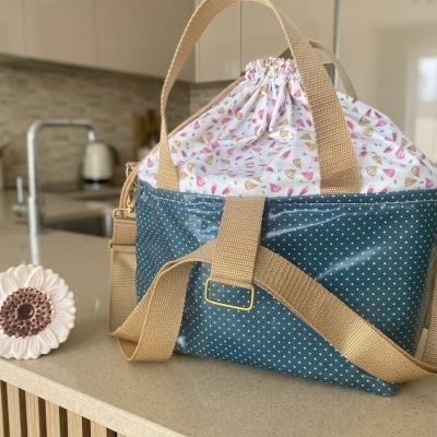 Mala de mão azul com bolinhas e interior floral na bancada da cozinha