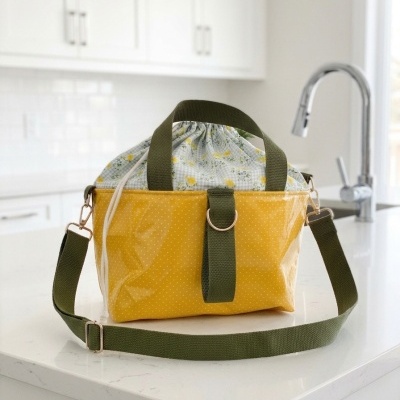 Saco amarelo com padrão de bolinhas brancas e alças verdes numa cozinha moderna