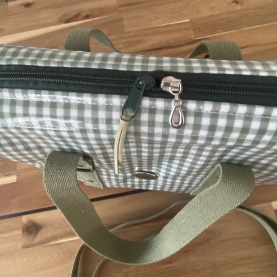 Bolsa xadrez verde claro e branco com fecho de correr preto e alça verde