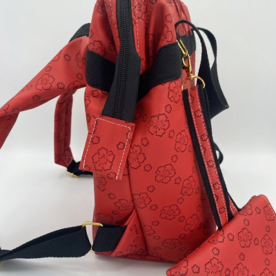 Mochila vermelha com padrão floral preto e detalhes em preto