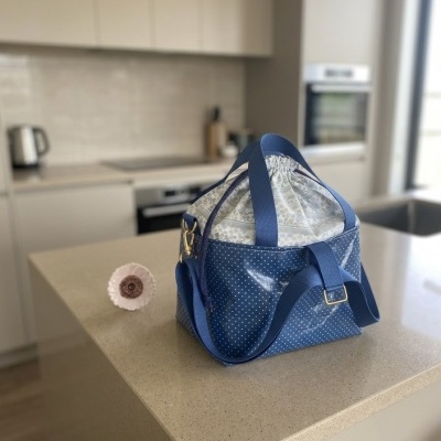 Bolsa térmica azul com alça larga em bancada de cozinha moderna