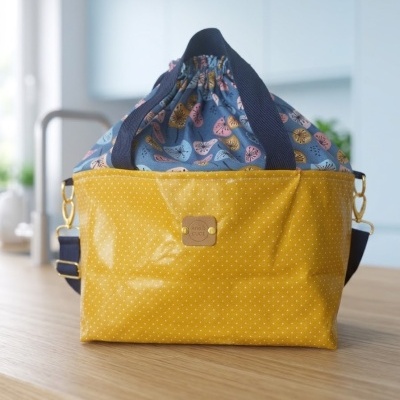 Bolsa amarela com padrão de pontos brancos e parte superior azul com padrão floral colorido