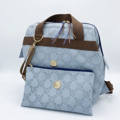 mochila azul clara com padrão de flores e alças castanhas