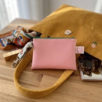 Bolsa amarela mostarda em tecido canelado com carteira rosa e lenço colorido numa mesa de madeira
