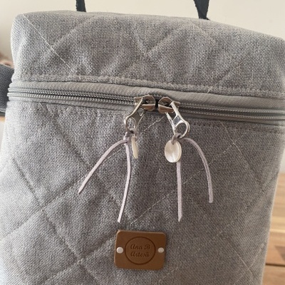 Mochila cinzenta com padrão em losangos e fecho de correr