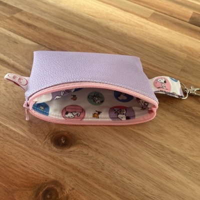 Estojo lilás pequeno com fecho rosa e interior estampado Snoopy e alça com mosquetão