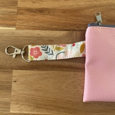 Porta-chaves com tiras floral e rosa em fundo de madeira
