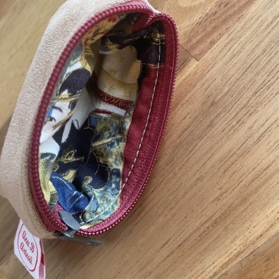 Carteira ou bolsa pequena de tecido com fecho vermelho e interior estampado