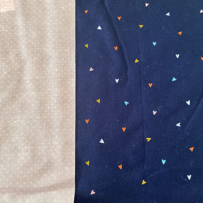 Tecidos bege com pontos brancos e azul escuro com corações coloridos