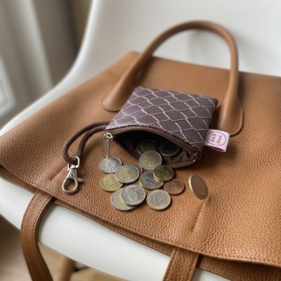 Bolsa castanha de couro com carteira castanha e moedas de euro