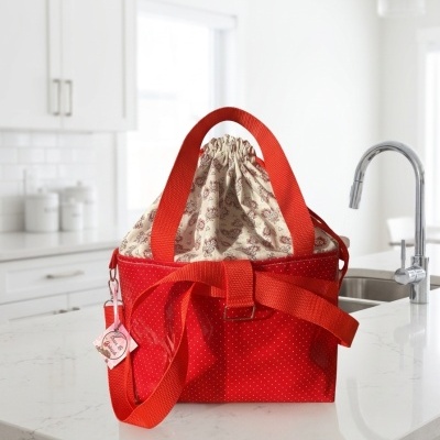 Bolsa vermelha com bolinhas brancas em bancada de cozinha branca