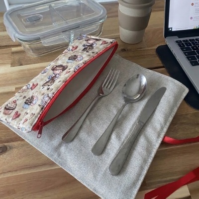 Conjunto de talheres com estojo e estojo temático, caixa de vidro e copo reutilizável em mesa de madeira