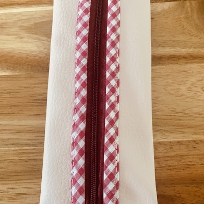 Estojo branco com fecho vermelho com padrão xadrez