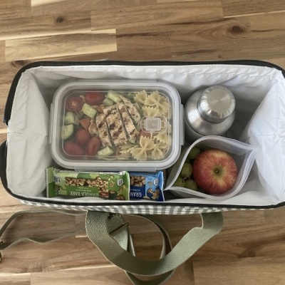 Mala térmica aberta com alimentos e bebida.