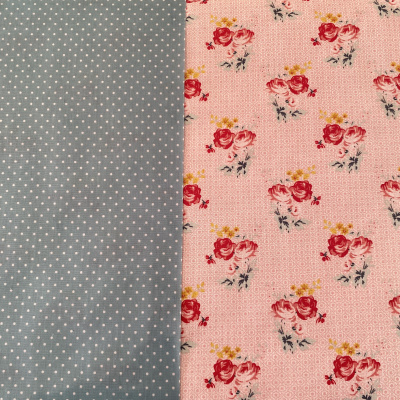 Dois tecidos lado a lado com padrões diferentes, um com bolinhas brancas sobre azul e outro com flores vermelhas e amarelas sobre rosa.
