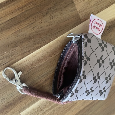 Bolsa pequena com padrão floral e fecho de correr, com pega de tecido cor-de-rosa e mosquetão metalizado