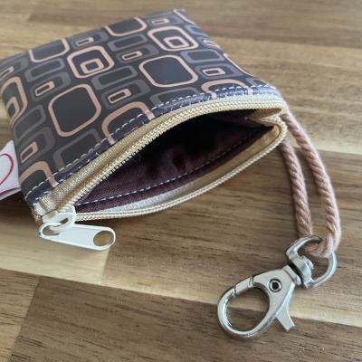 Bolsa pequena com padrão geométrico marrom e bege com fecho e alça