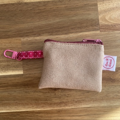 Carteira pequena bege com fecho rosa e correia rosa com bolinhas brancas