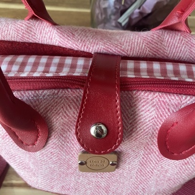 Mala rosa com alças vermelhas e padrão aos quadrados interior