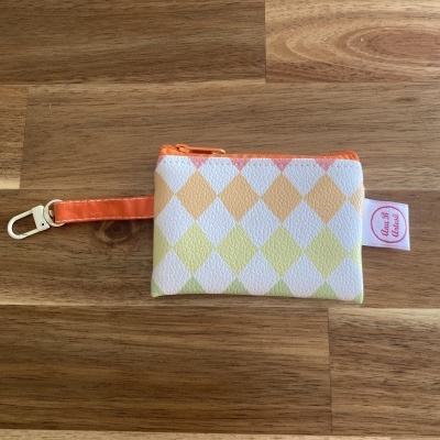 Bolsa pequena colorida com padrão de losangos e fecho laranja